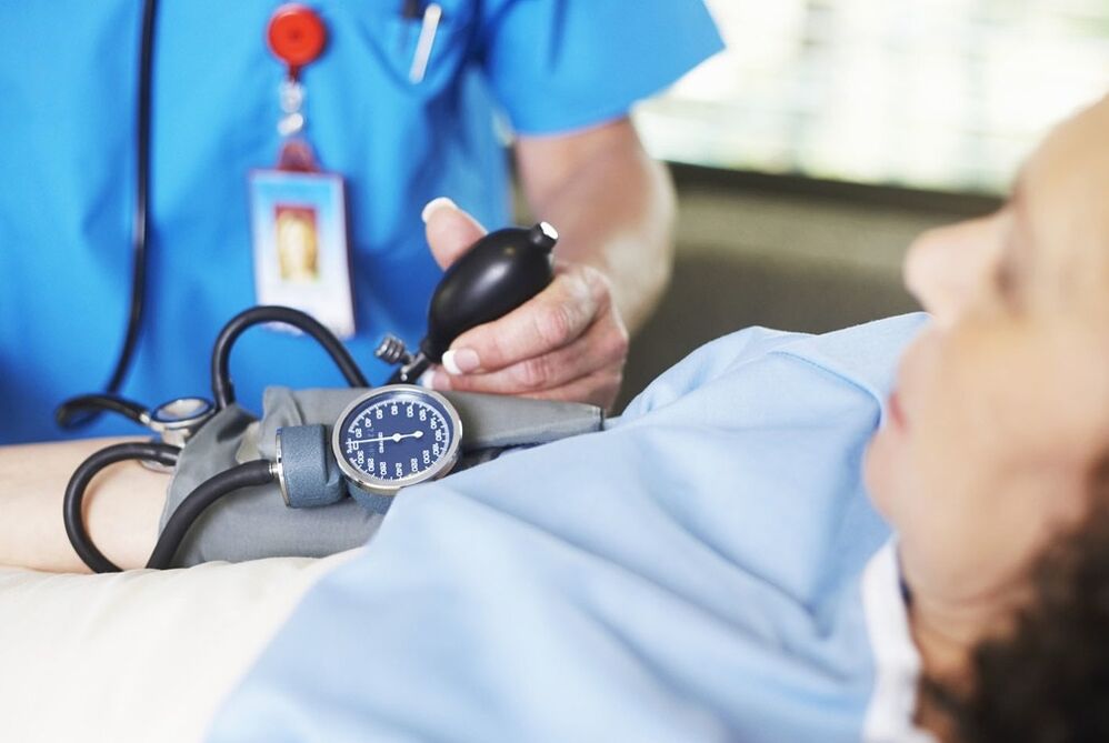 Arst mõõdab patsiendi survet hüpertensiooniga